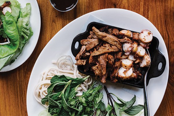 At Lure in Atlanta, a shareable dish of grilled octopus and pork is served with lettuce wraps, mixed herbs and Vietnamese sauce.