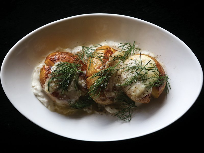 At Selden Standard in Detroit, melty, on-trend raclette elevates a dish of smoked potatoes with crème fraîche and dill.