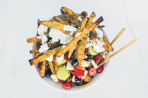 The crisp flavors of a Greek salad harmonize effortlessly with seasoned fries, while a cool, tangy tzatziki sauce extends the Mediterranean theme.